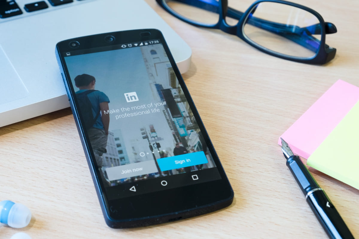 celular mostrando o linkedin: linkedin para empresas página inicial do LinkedIn no celular