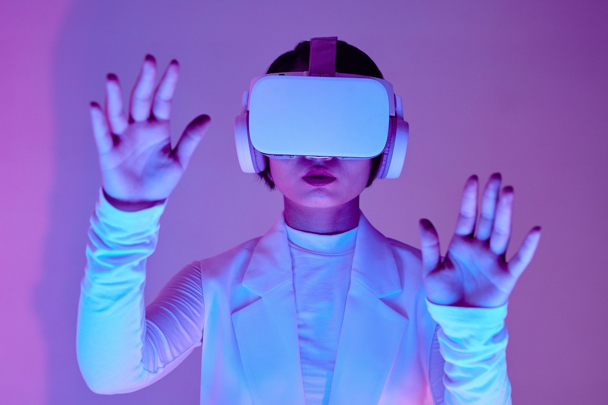 óculos de realidade virtual: marketing no metaverso mulher toda de branco usando um óculos de realidade virtual branco