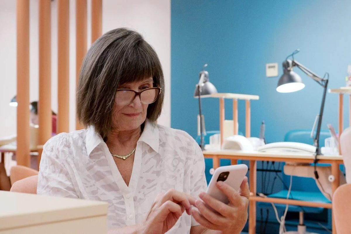 mulher usando o celular: marca interativa mulher mais velha mexendo no celular