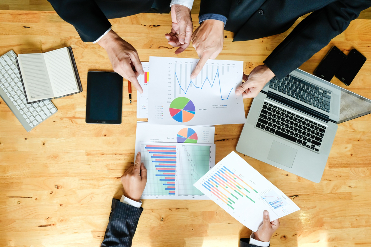 pessoas trabalhando juntas e analisando gráficos