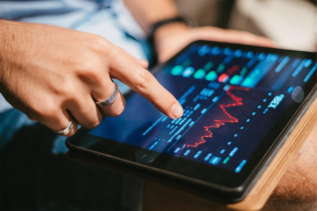 mercado de ações: nft marketing Homem verificando dados do mercado de ações no tablet