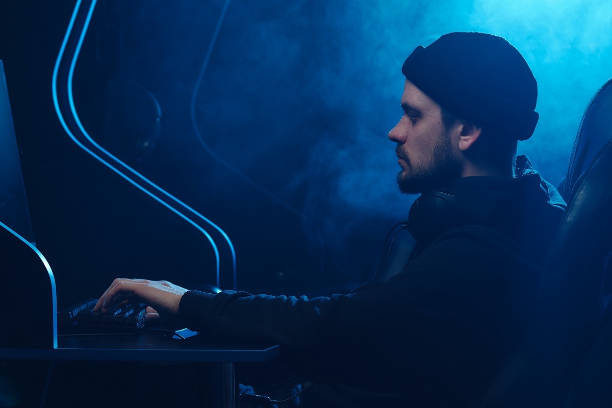 homem de perfil digitando no teclado de um computador