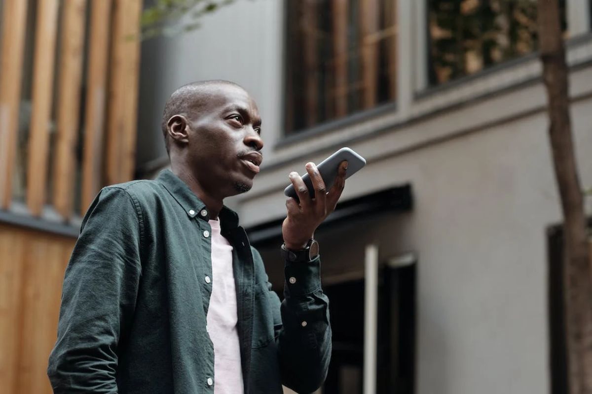 homem andando e mandando mensagem de voz pelo celular