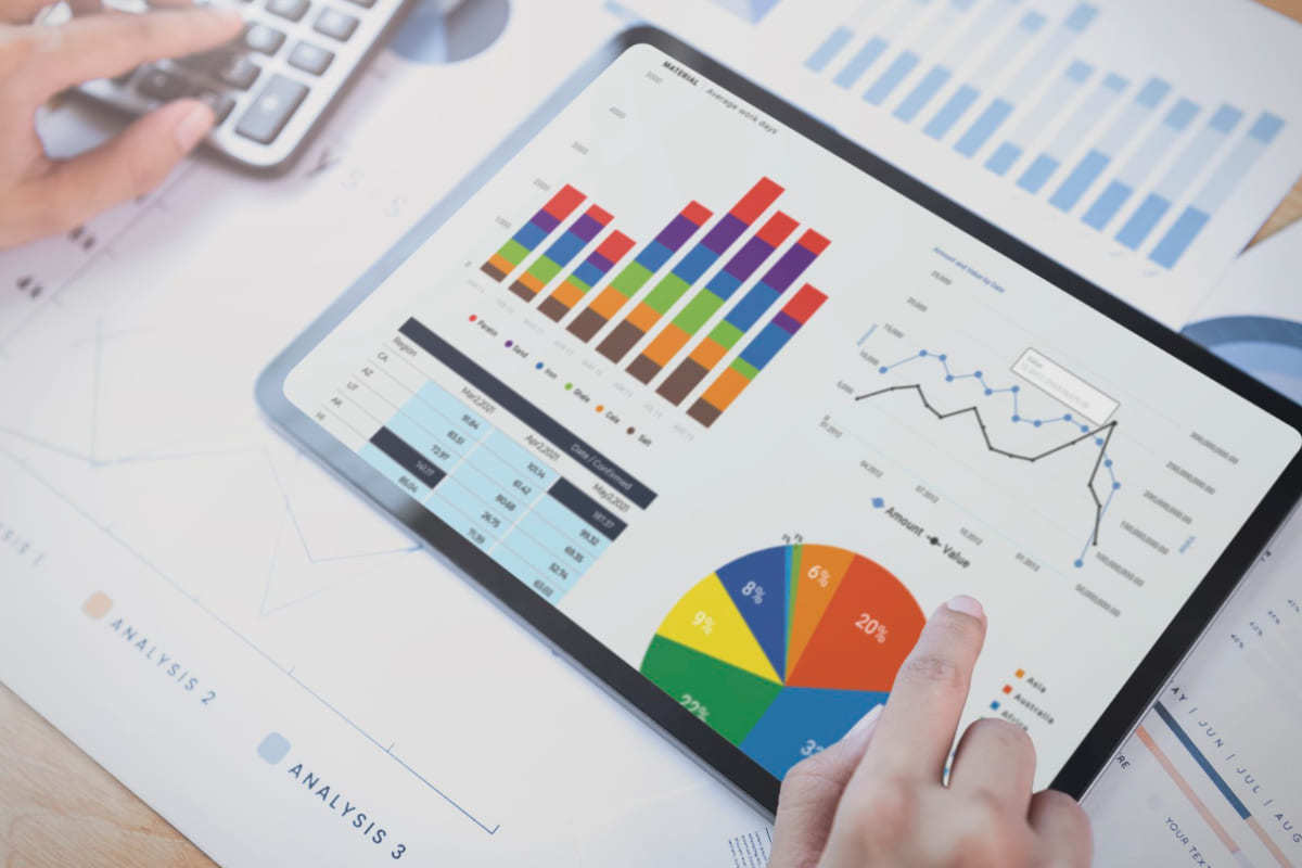 Análise de dados: planejamento estratégico Pessoa usando tablet para verificar relatórios sobre impressões de relatórios e usando calculadora