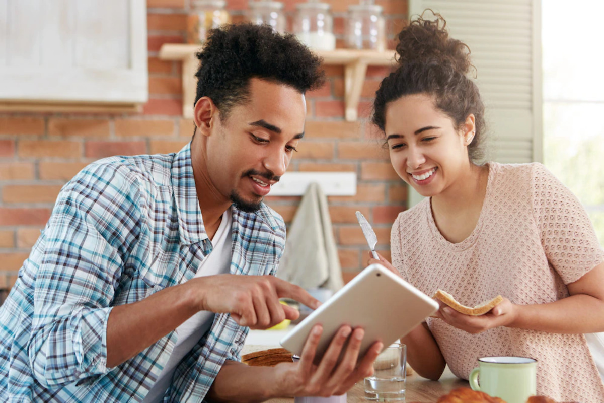 homem apontando algo em um tablet para uma mulher