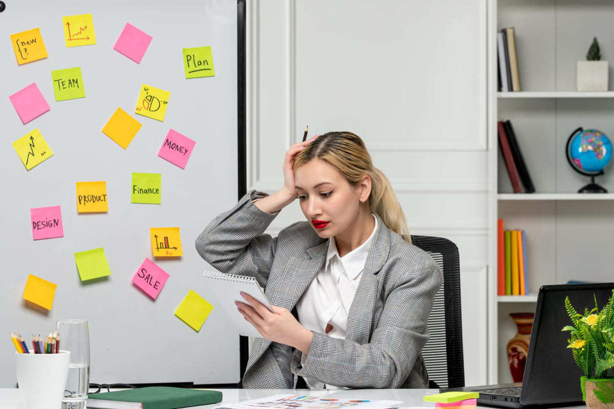 mulher no trabalho: erros e-commerce mulher no trabalho, analisando uma folha de papel e com a mão na cabeça