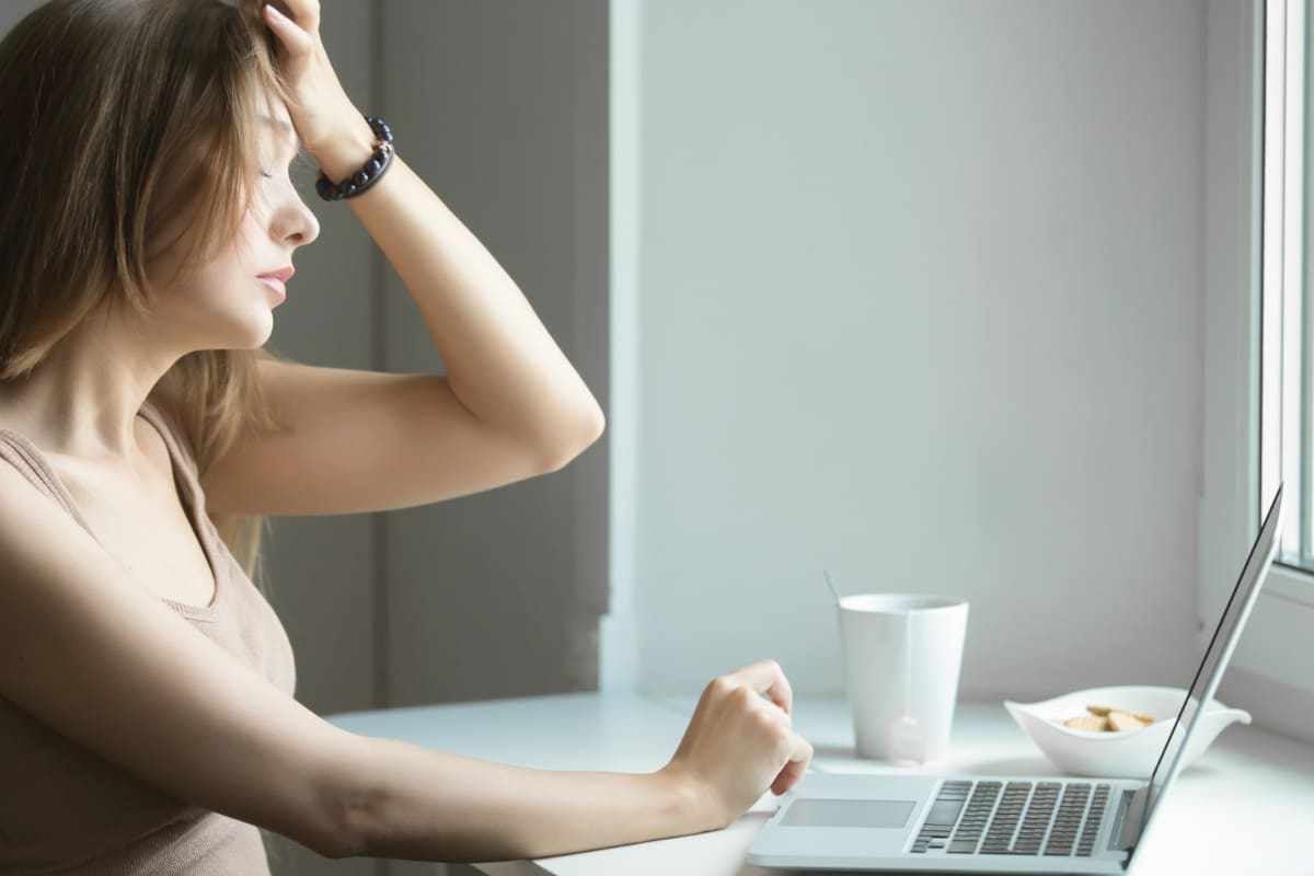 mulher usando laptop: erros e-commerce mulher usando o laptop, com a mão na cabeça