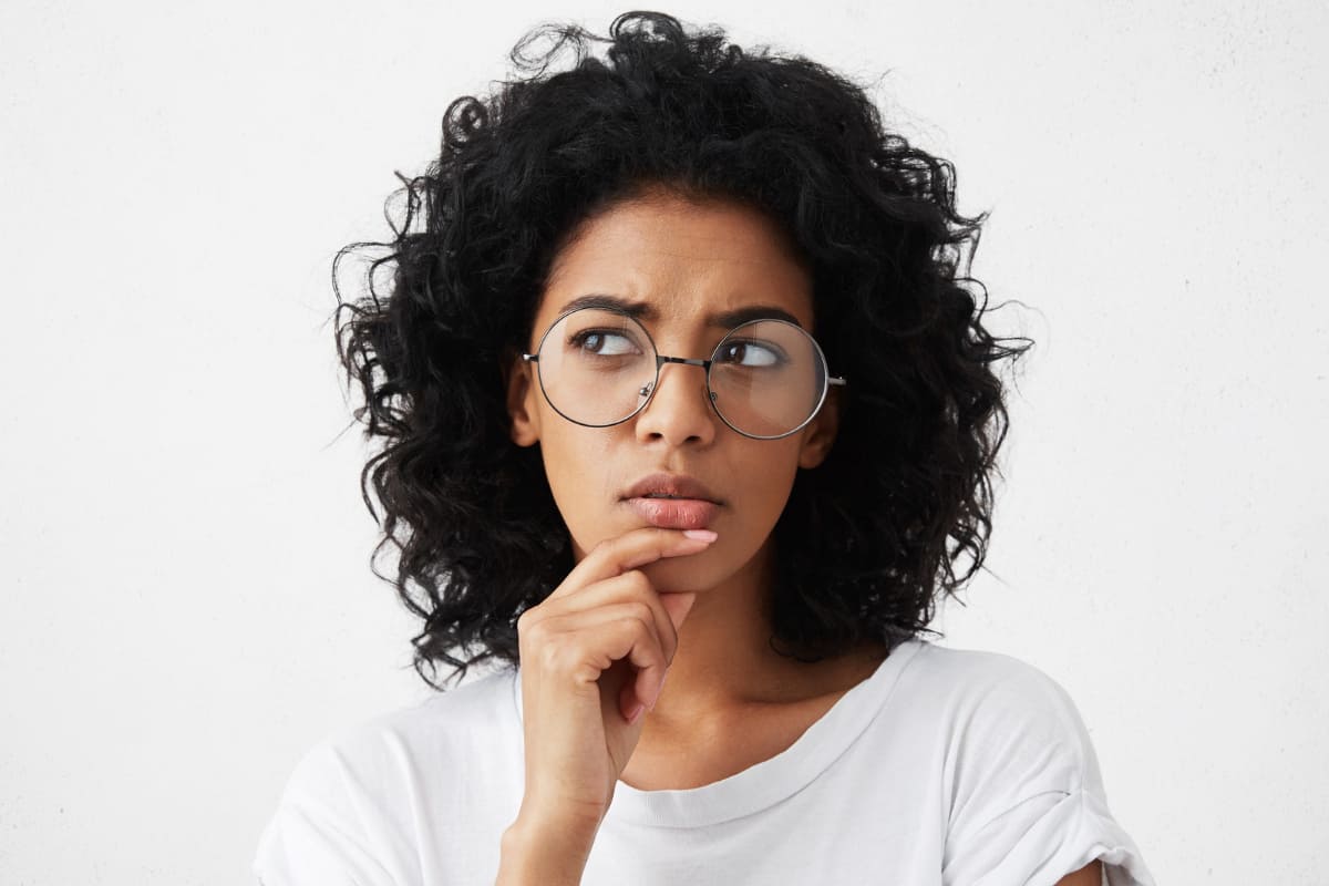 mulher pensativa: gatilhos mentais Retrato isolado de mulher jovem e elegante, tocando seu queixo