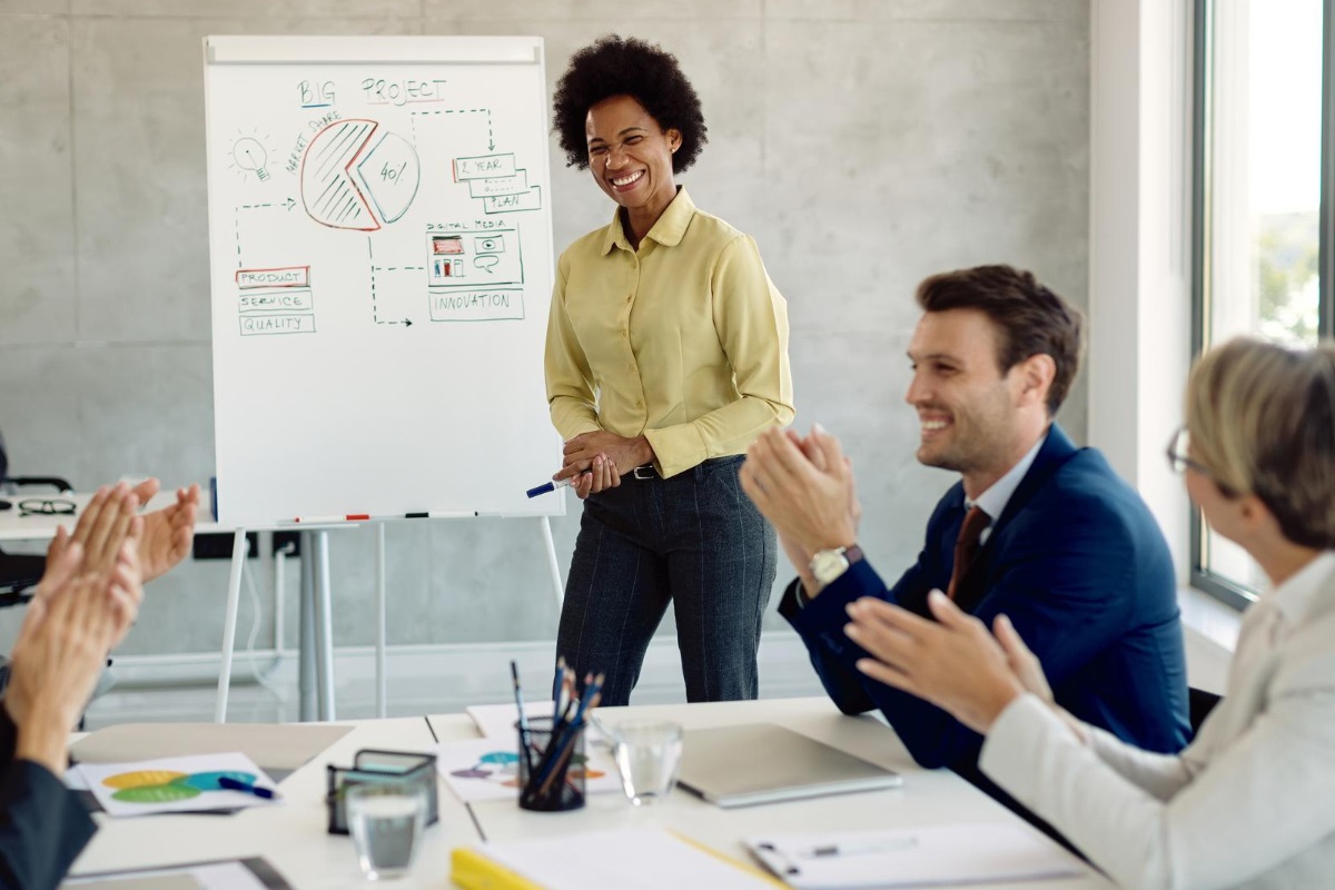 pessoas em reunião: gestão de pessoas mulher de pé apresentando gráficos para seus colegas