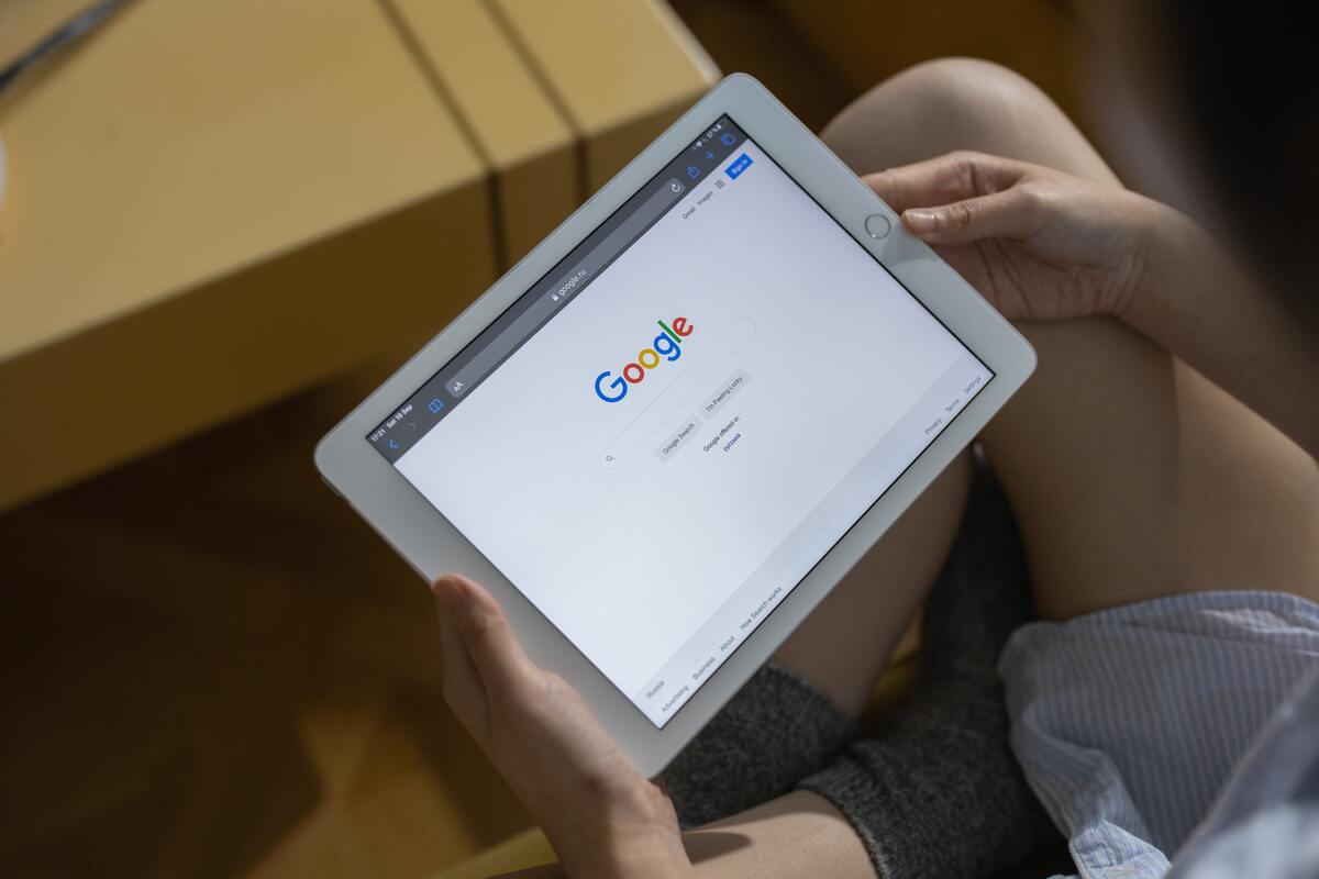 Buscador no tablet: google imagens página inicial do Google aberta em um tablet, segurado por mulher sentada