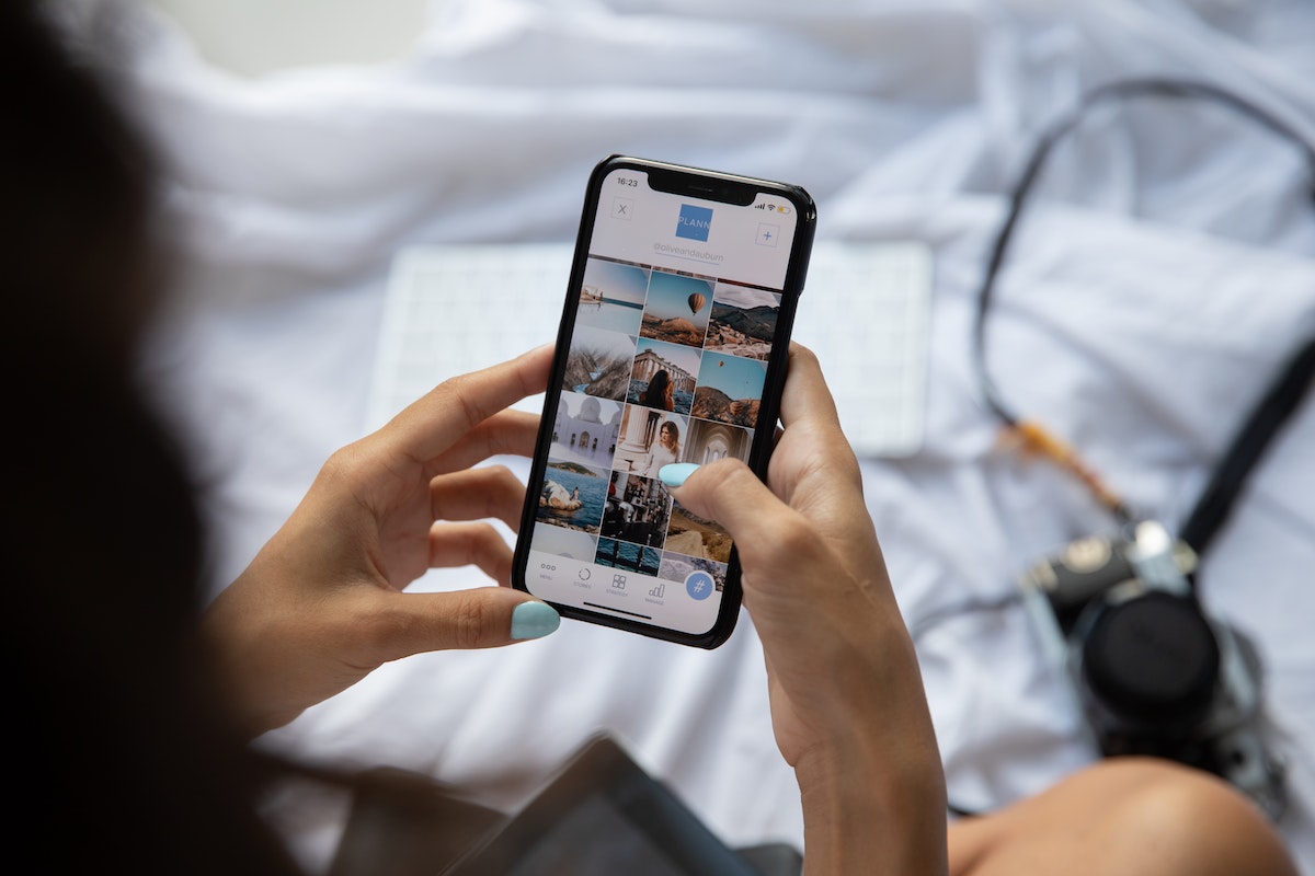 Mulher usando smartphone: SEO para Pinterest Mulher usando smartphone em pinterest em sua cama com alguns itens espalhados
