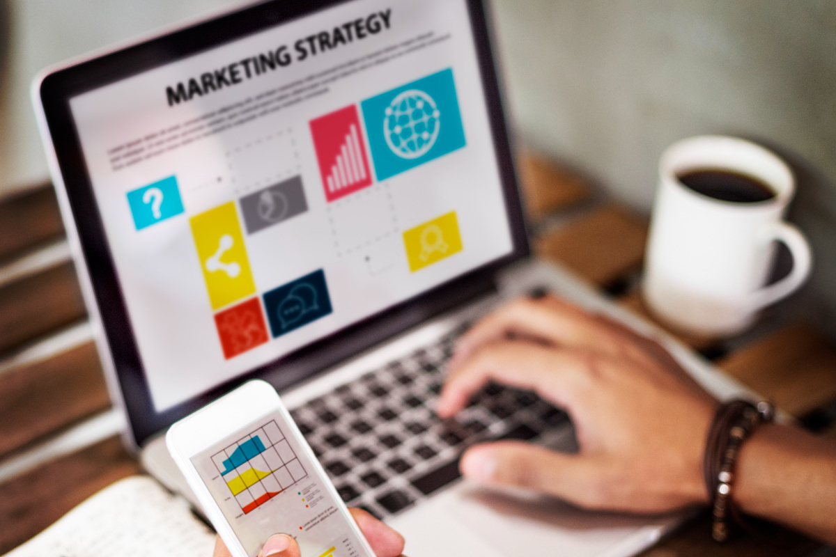 laptop: marketing 4.0 mão masculina digitando em um laptop com um celular na outra mão