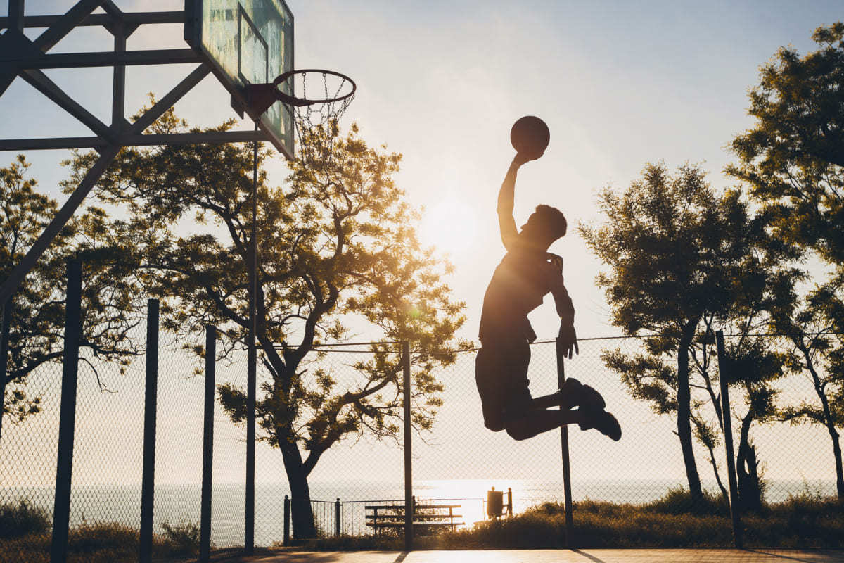 homem jogando basquete: marketing esportivo homem jogando basquete ao ar livre