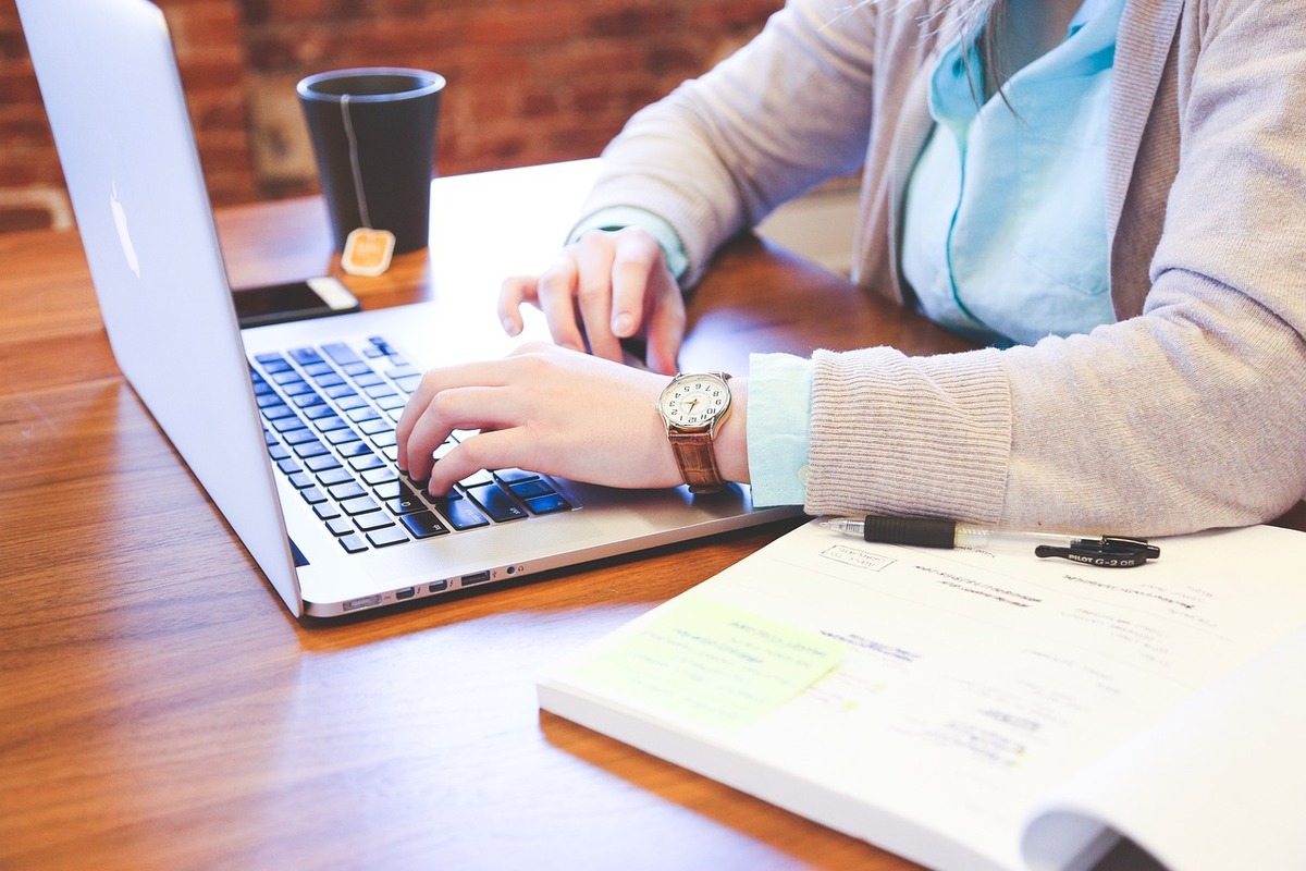 pessoa trabalhando: marketing operacional pessoa trabalhando em seu laptop, com uma xícara de chá do lado