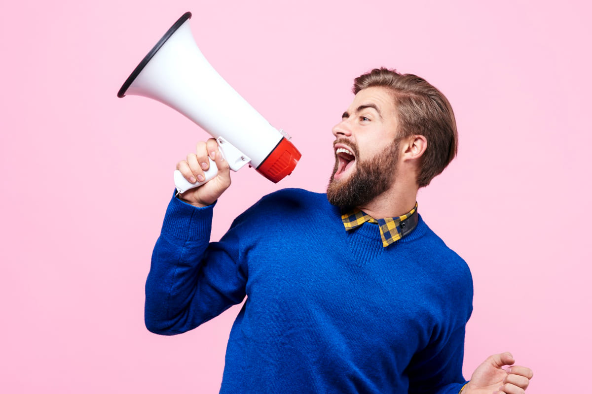 homem com megafone: marketing pessoal homem com um megafone na mão em um fundo cor de rosa