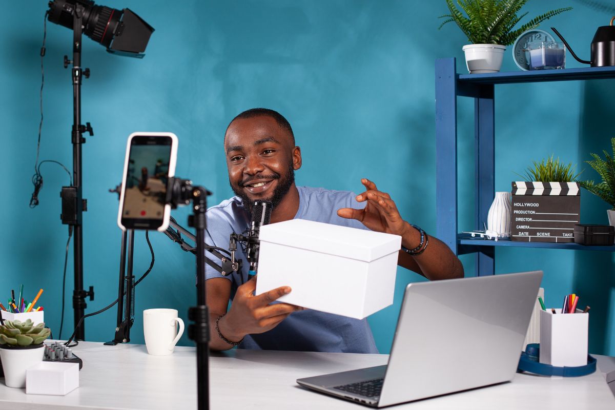 homem gravando vídeo: motivos para investir em conteúdo homem sentado, usando o celular para gravar vídeo