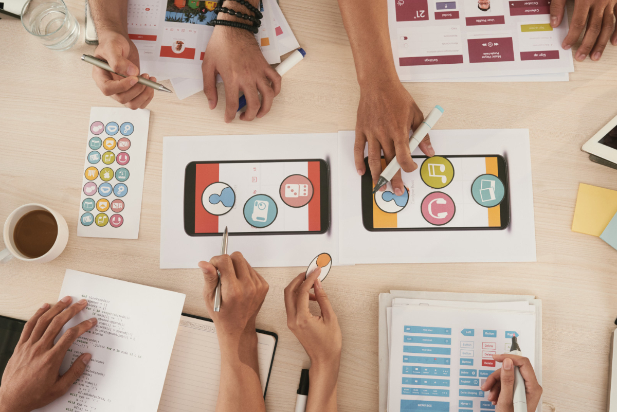 Pessoas traçando estratégias: Philip Kotler pessoas traçando estratégias em conjunto sobre mesa de madeira