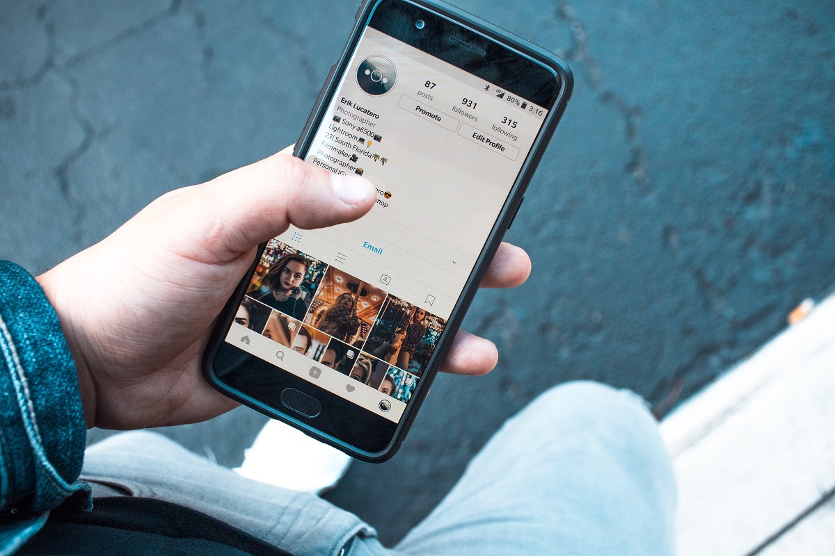 pessoa acessando o instagram: remarketing no instagram pessoa usando o celular para acessar o instagram