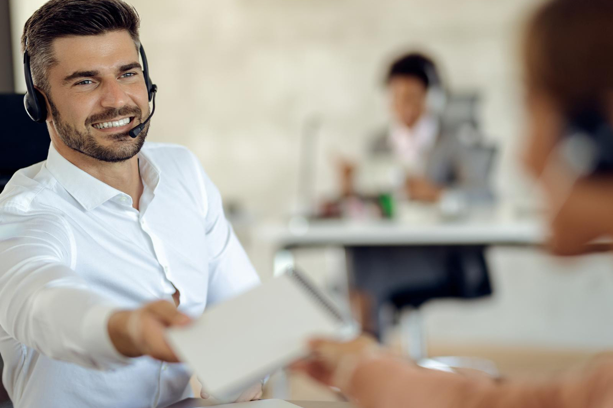 atendente no trabalho: trabalhar com vendas atendente entregando um caderno para sua colega de trabalho
