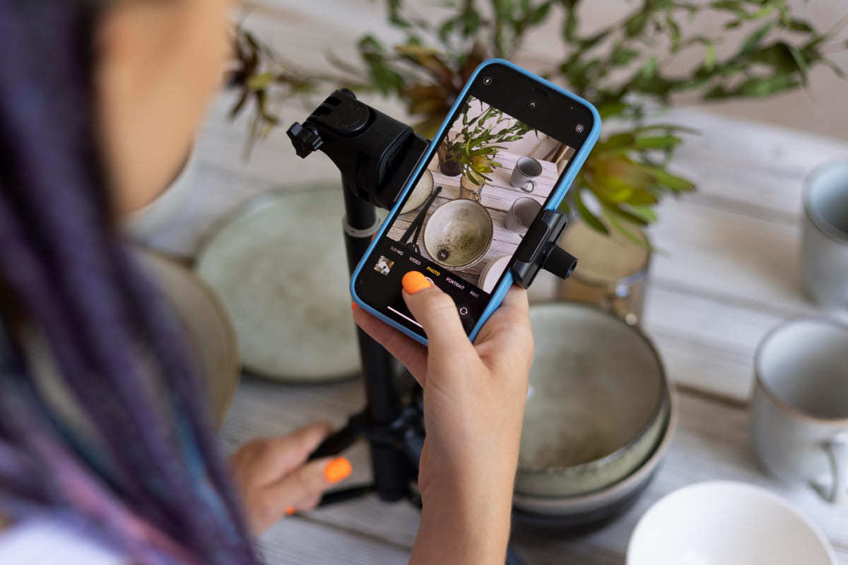 Foto: Aplicativos de fotos Mulher em restaurante usando celular para tirar foto de decoração de mesa