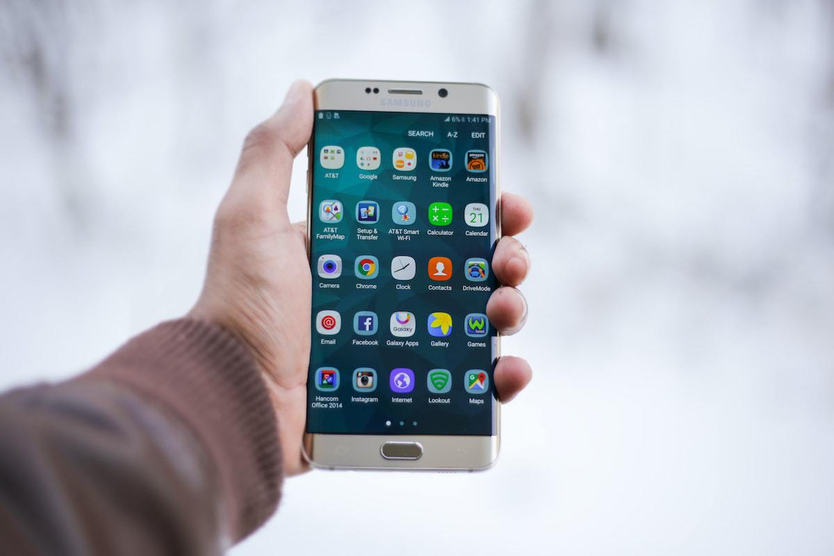 Smartphone: app store optimization Pessoa segurando smartphone em tela de menu de aplicativos