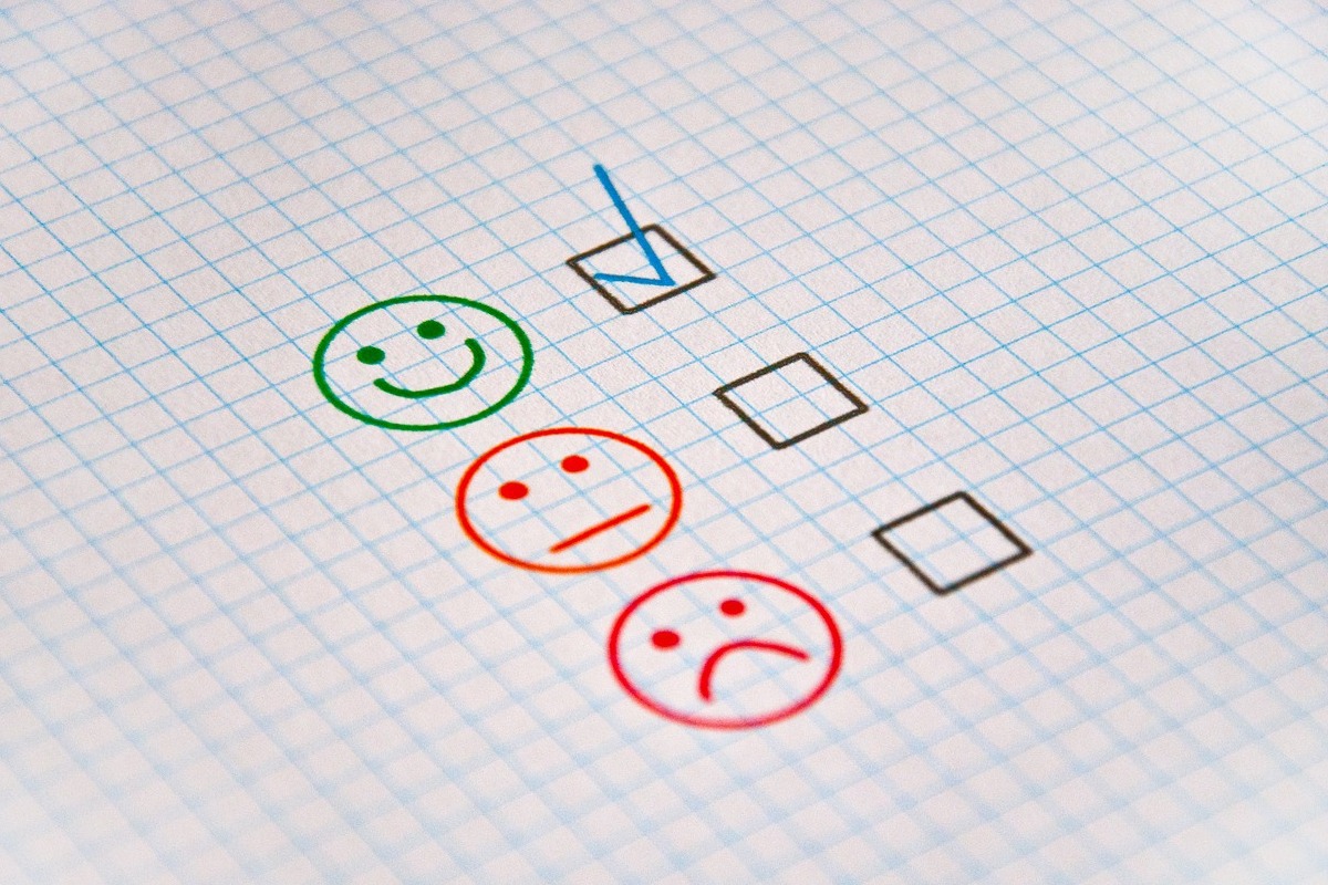 Checklist: employer branding Folha com pequenos quadrados em sua superfície com rostinho verde análogo à emoji com quadrinho marcado ao lado, acima de duas carinhas vermelhas com ar triste com quadros desmarcados à direita