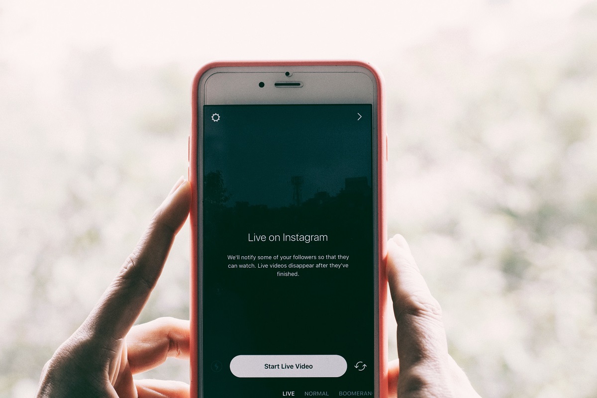 Pessoa segurando celular com tela exibindo live no instagram