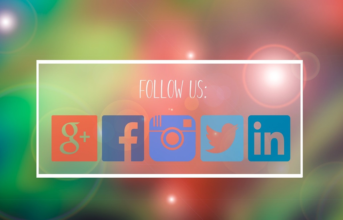 Redes sociais: Marketing baseado em contas Montagem com luzes ao fundo em desfoco e frase Follow Us e símbolos de aplicativos abaixo