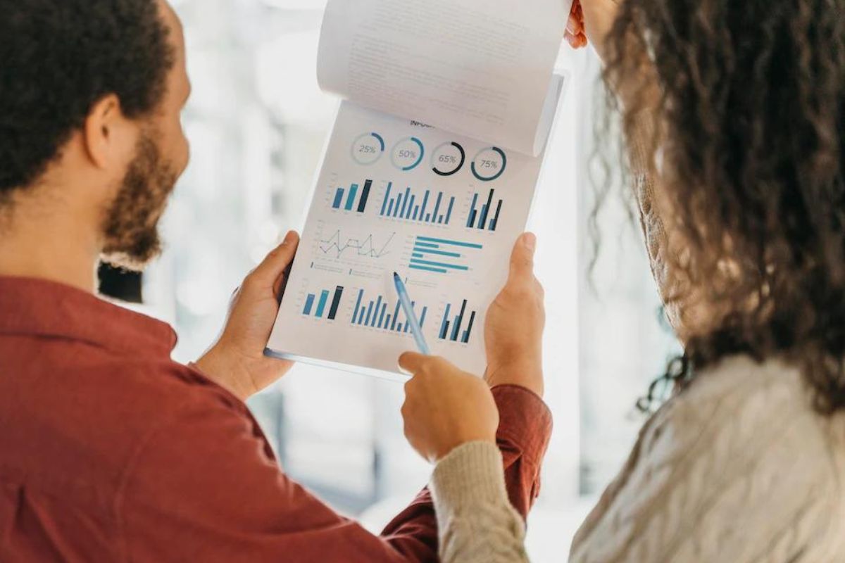 Local de trabalho: Marketing de resultados Homem e mulher em local de trabalho analisando dados em folhas a4 impressas e posicionadas em prancheta