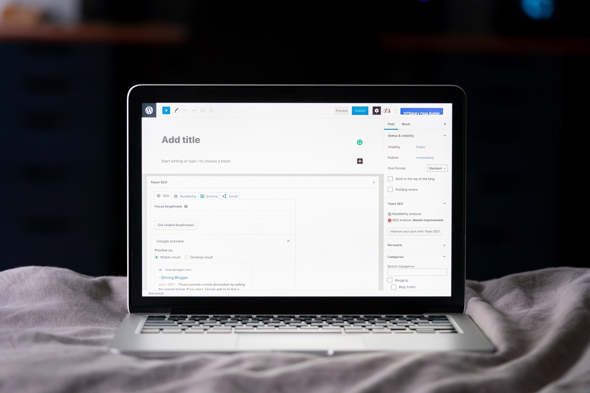 Notebook sobre pano branco com tela de postagem do WordPress aberta