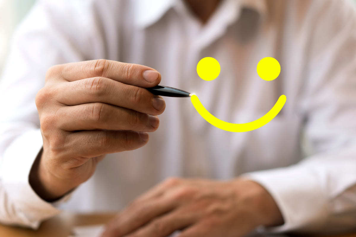 Montagem: onboarding Homem segurando caneta enquanto desenha no ar um rosto sorrindo em montagem