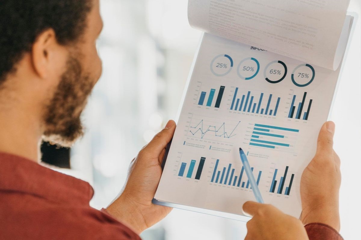 Dados impressos: Processos de marketing Homem segurando dados impressos em folhas a4 e fixados em prancheta