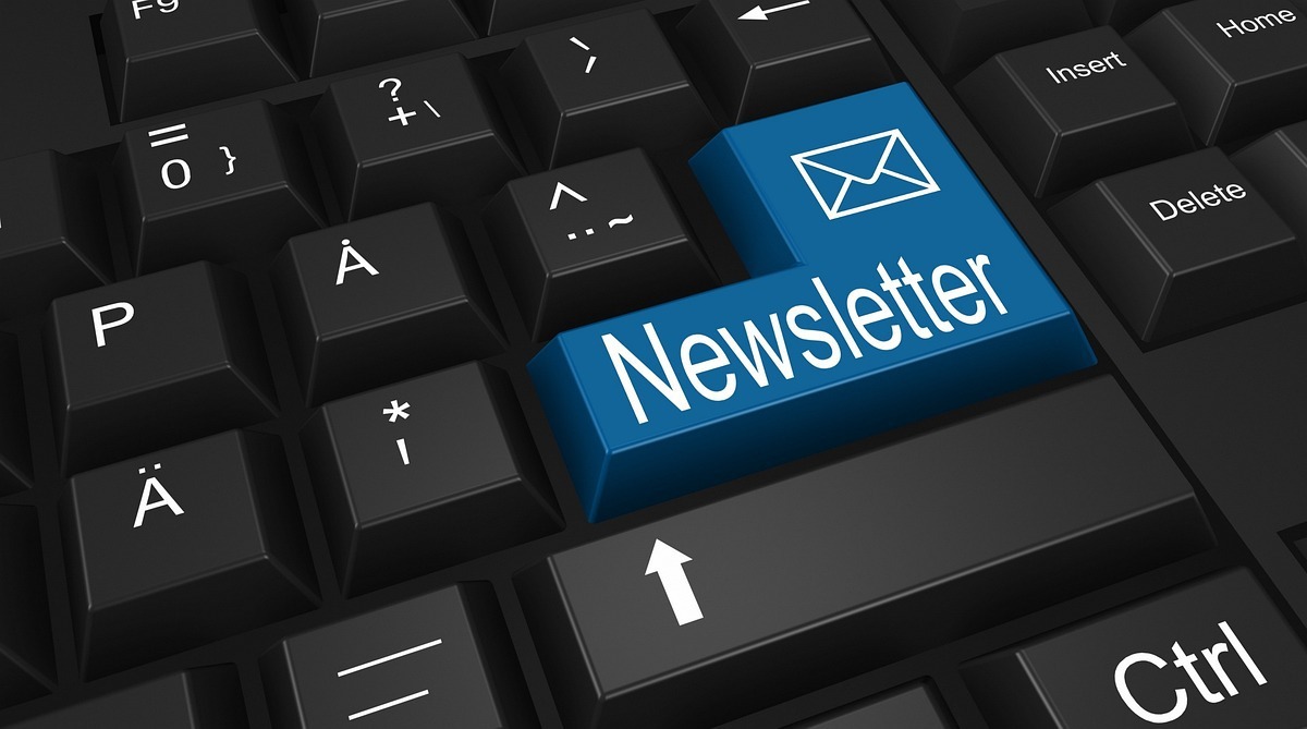 Teclado: Remarketing no e-commerce Fotografia de foco em teclado preto de computador com tecla azul com nome e símbolo de newsletter no local do Enter