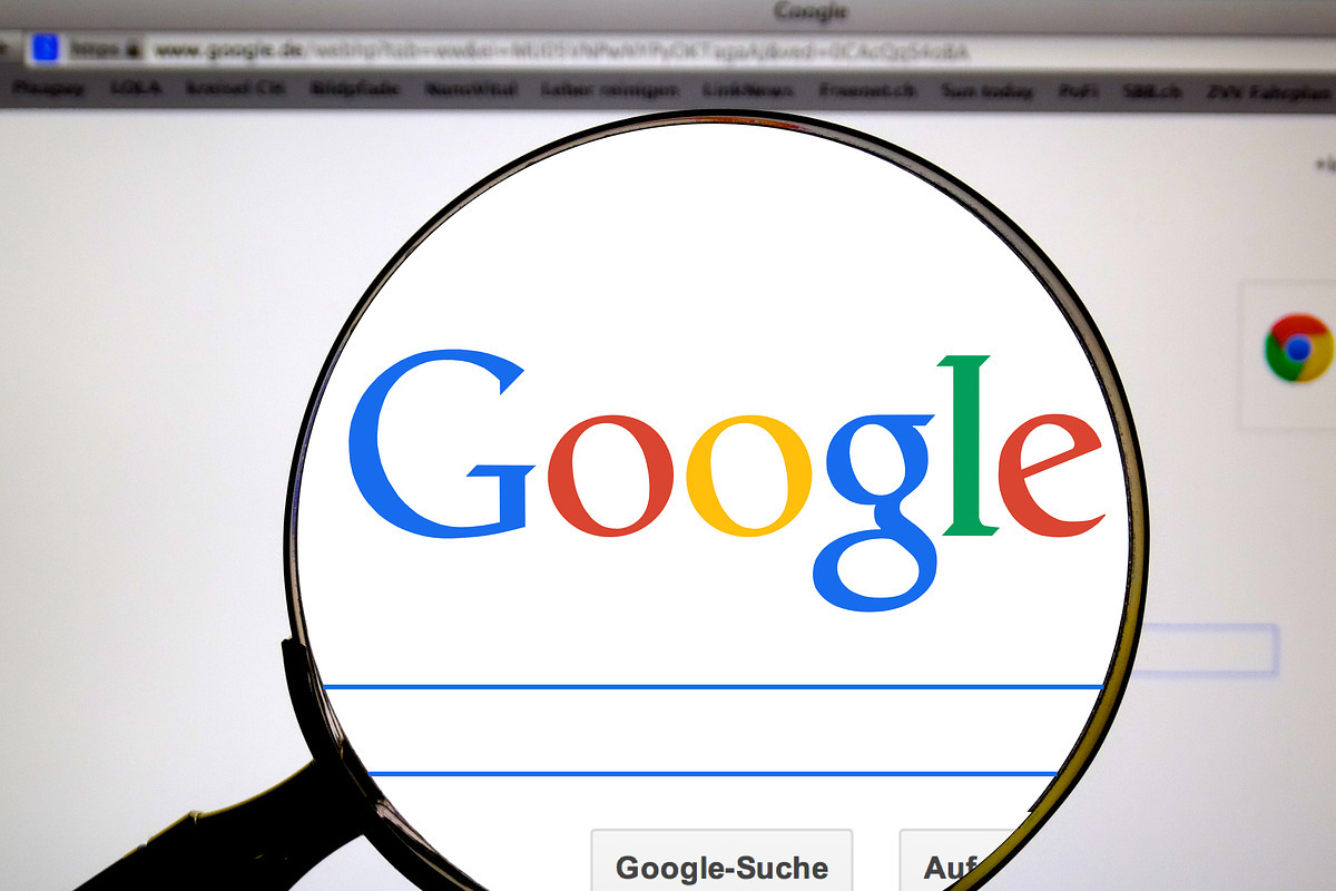 Lupa diante do tela de computador com foco no nome Google enquanto acessa tela inicial de pesquisa do site citado