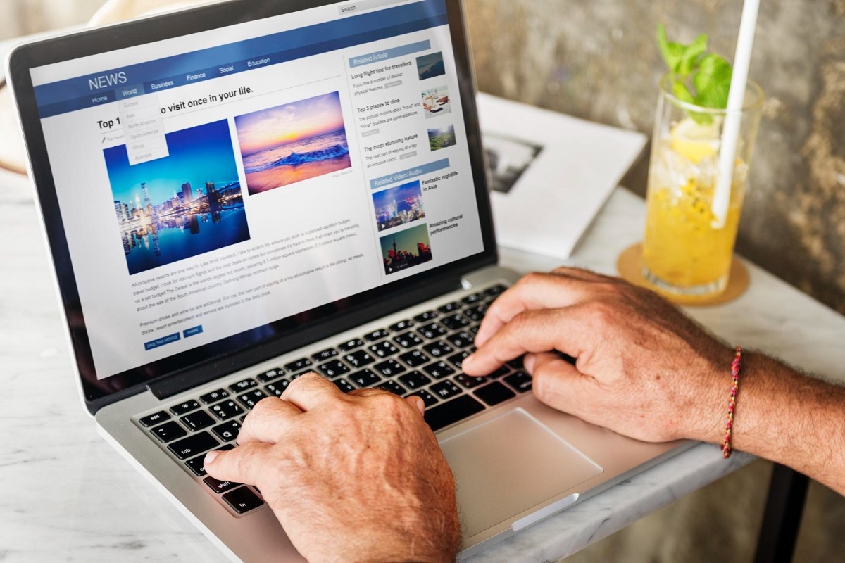 Notícias: Tempo de permanência na página Homem lendo notícias em notebook sobre mesa com copo de suco à direita