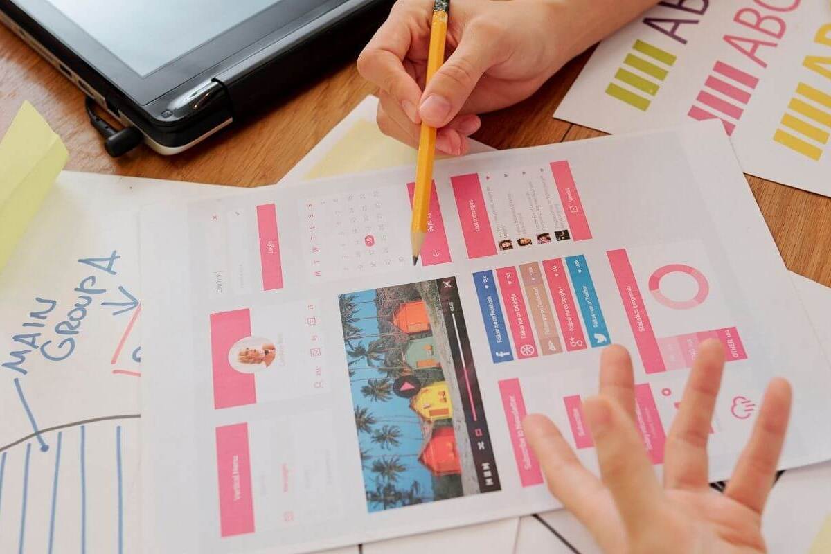 Modelos impressos: Testes AB para landing pages Pessoa sentada diante de mesa analisando modelo de landing page impresso e colocado sobre a mesa