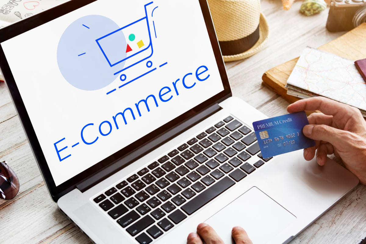 compras online: Tipos de e-commerce pessoa usando um laptop e um cartão de crédito para fazer compras online