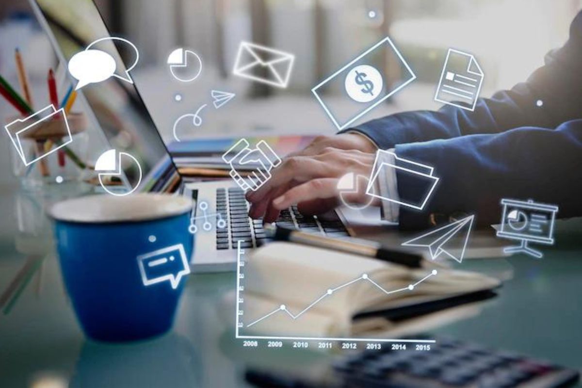 Montagem: Unir marketing e vendas Montagem com homem digitando algo em notebook com caneca azul à esquerda e símbolos web de e-mail e mensagens no ar