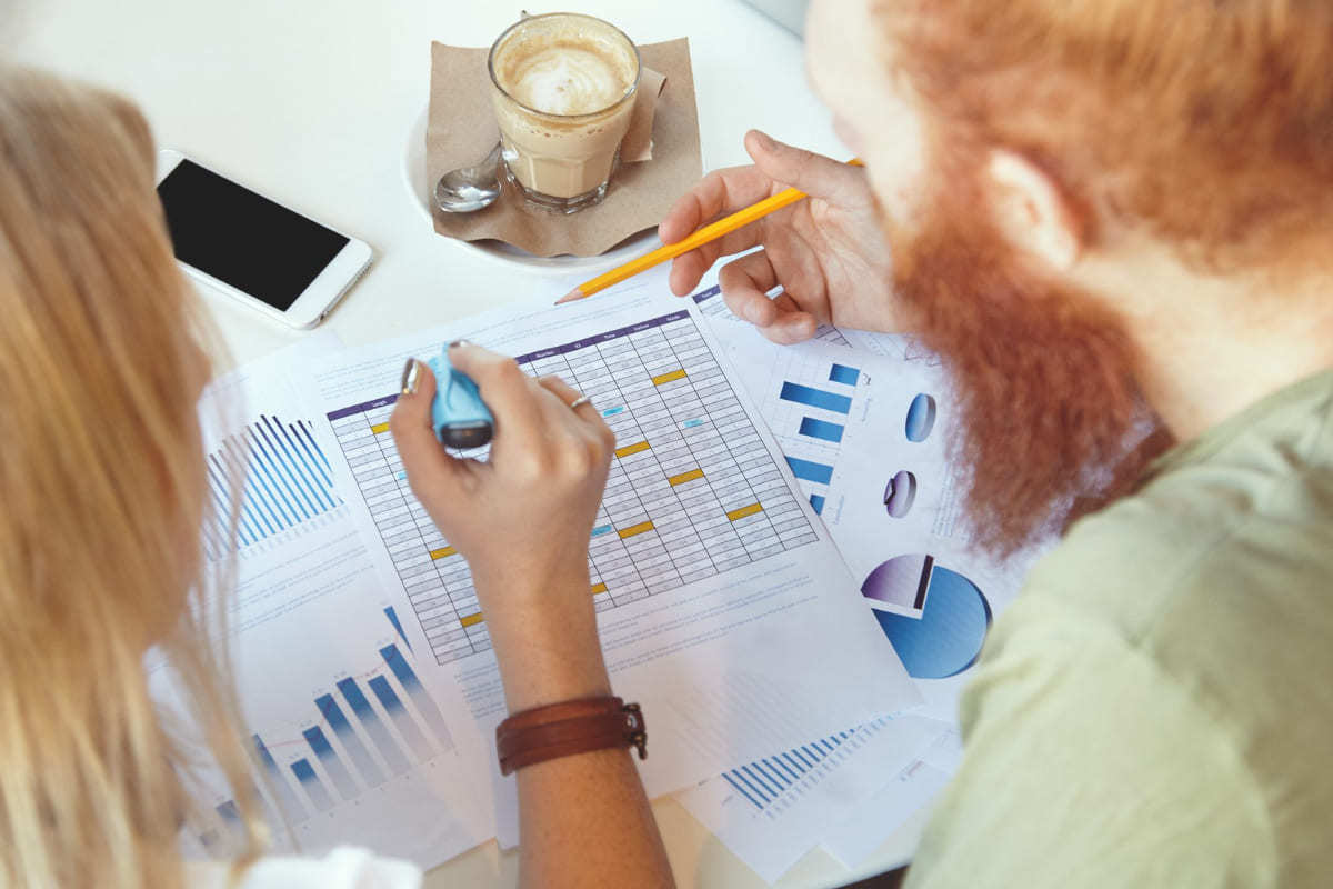 Como a análise preditiva pode melhorar os resultados da sua empresa? duas pessoas sentadas, analisando relatórios