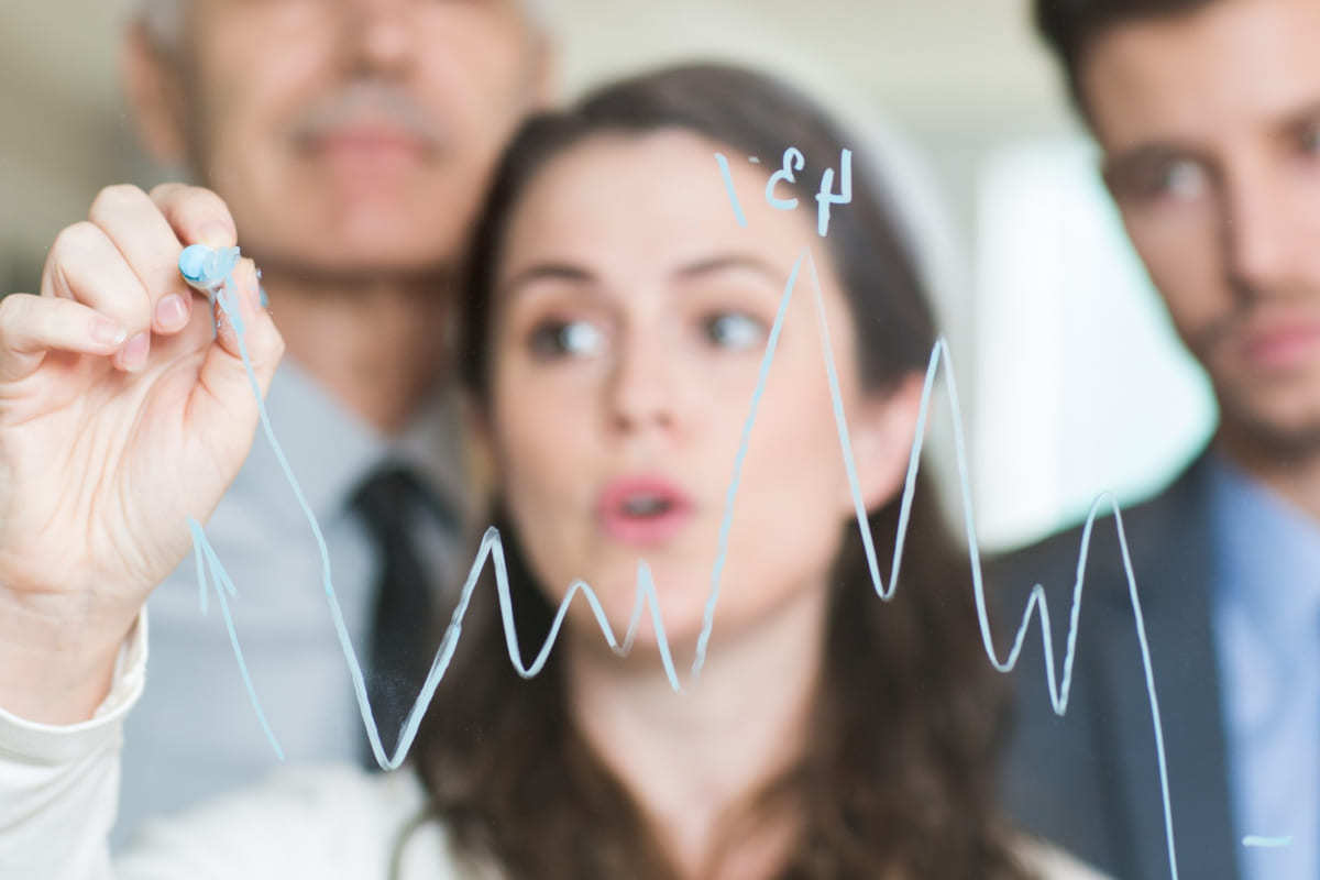 mulher desenhando gráfico: análise preditiva mulher desenhando um gráfico de linhas em um quadro