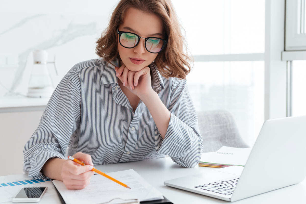 mulher analisando relatórios: analista de seo mulher sentada, analisando relatórios