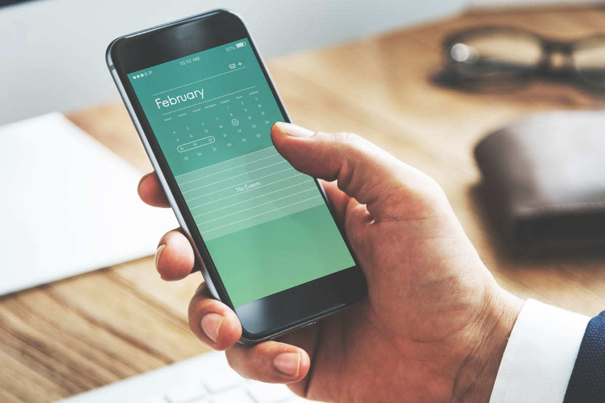 homem usando o celular para ver calendário