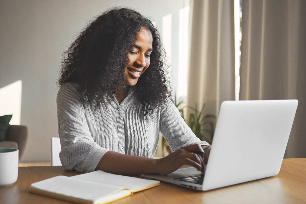 mulher sentada, trabalhando em seu laptop