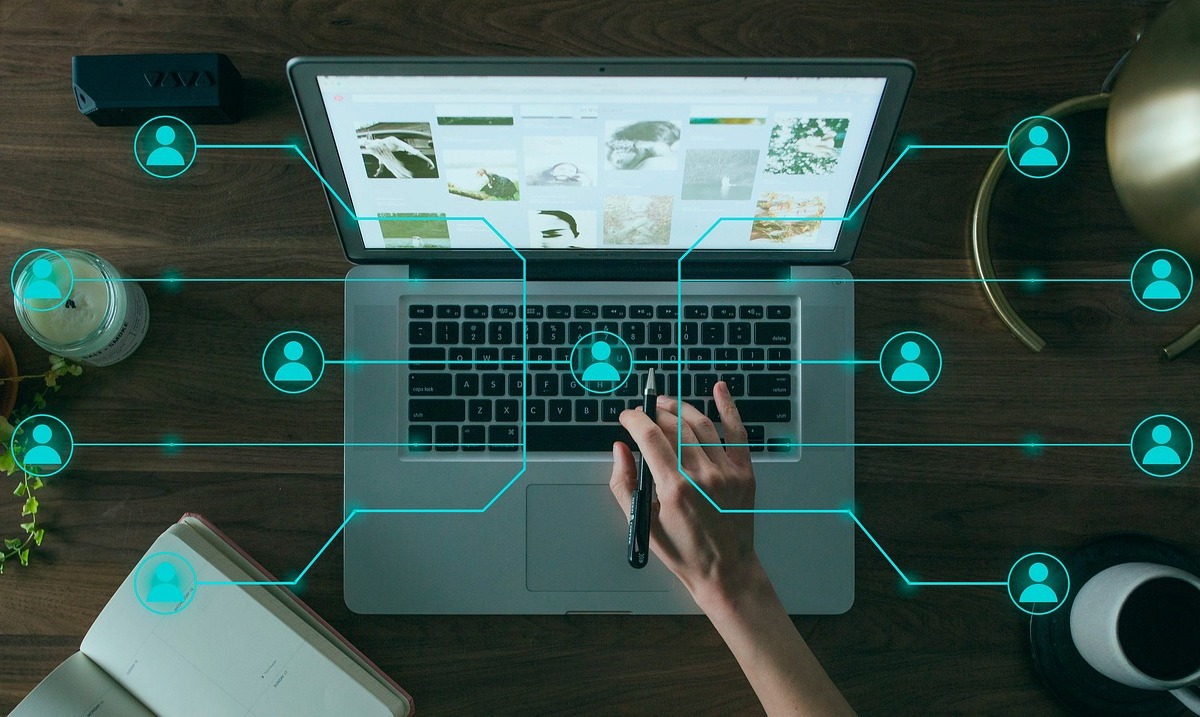 pessoa usando laptop: blog corporativo pessoa usando o laptop e na imagem, vários ícones de pessoas se interligando