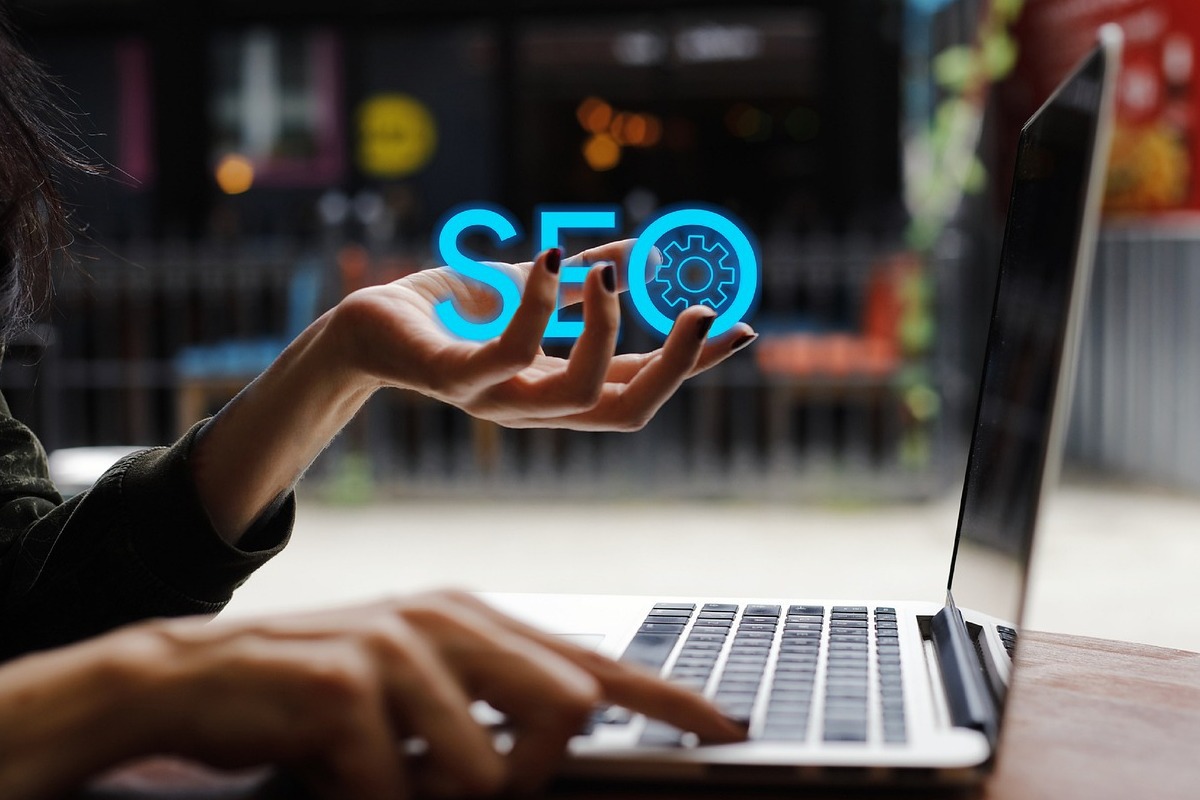 laptop: blog corporativo pessoa trabalhando em seu laptop e segurando o nome seo