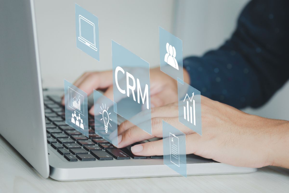 Pessoa digitando no notebook: Como escolher CRM Com escolher CRM: A imagem mostra uma pessoa digitando em um notebook.