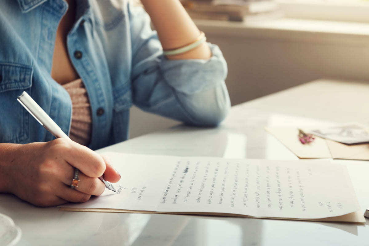 mulher escrevendo: como escrever bem mulher sentada, escrevendo em uma folha de papel