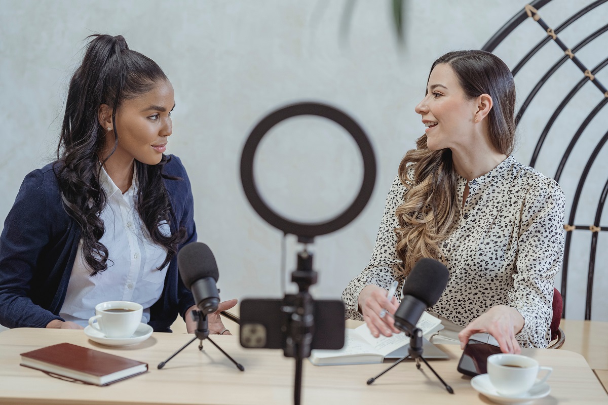 Mulheres em gravação de um podcast: Como produzir um vídeo Como produzir um vídeo: A imagem mostra duas mulheres durante a gravação de um podcast.