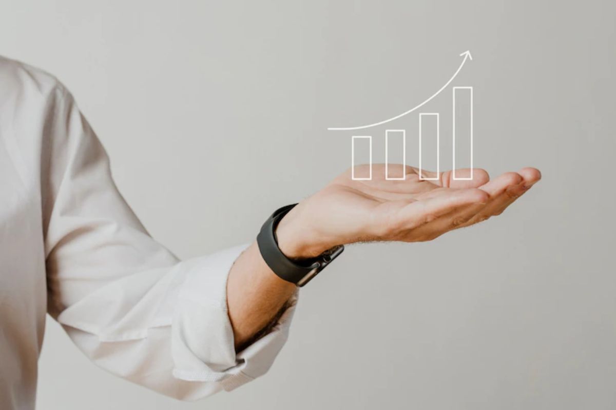 Homem com um desenho de gráfico nas mãos: Conteúdo para impulsionar vendas Conteúdo para impulsionar vendas: A imagem mostra um homem com a mão aberta e sobre ela um desenho de um gráfico