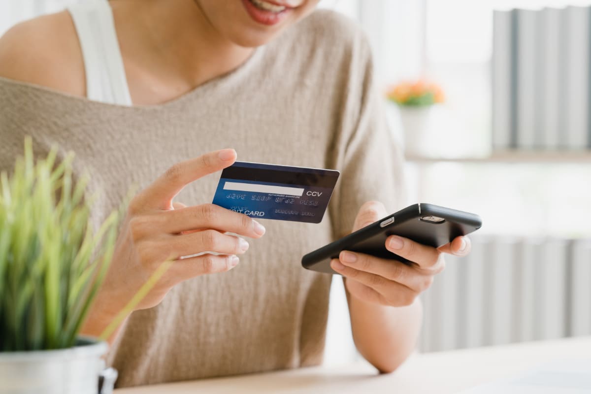 Fazer propaganda: A imagem mostra uma pessoa usando um smartphone para realizar compras online. 
